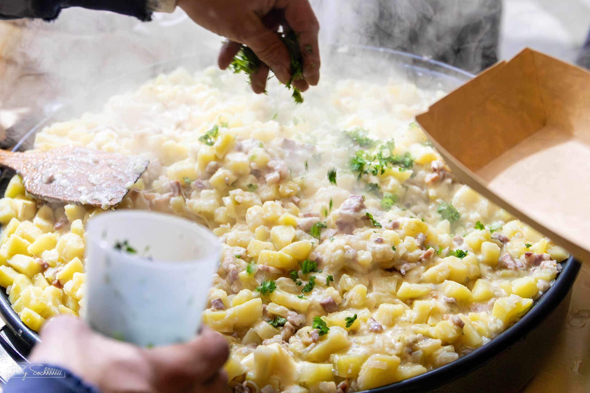 Grande poêle de tartiflette parsemée d'herbes