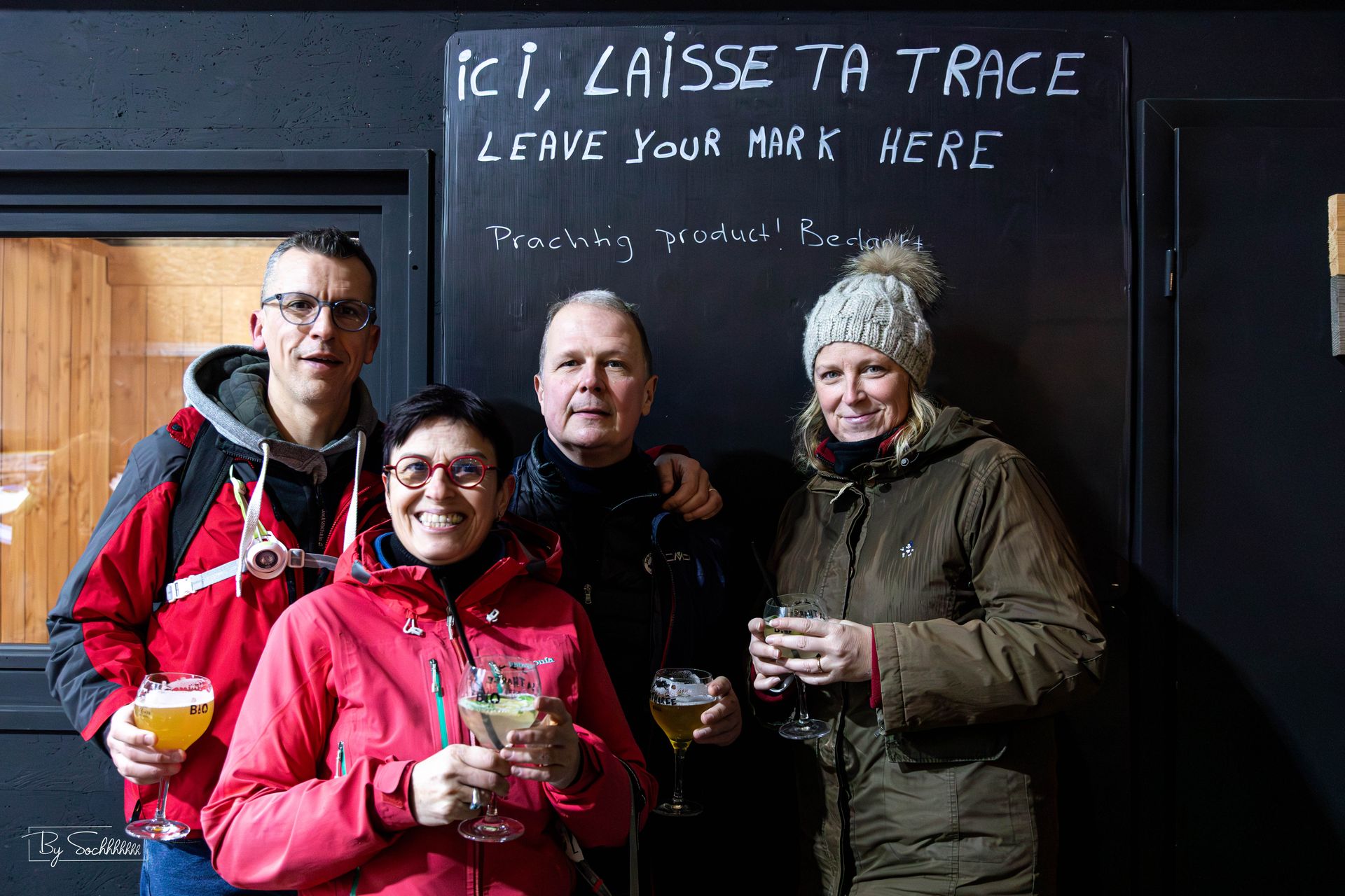 Groupe devant le mur « Laisse ta trace » à la brasserie